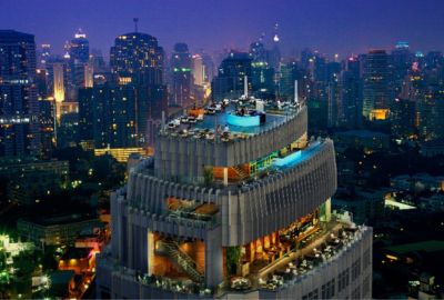 Aerial view of a rooftop bar and restaurant at night in Bangkok.