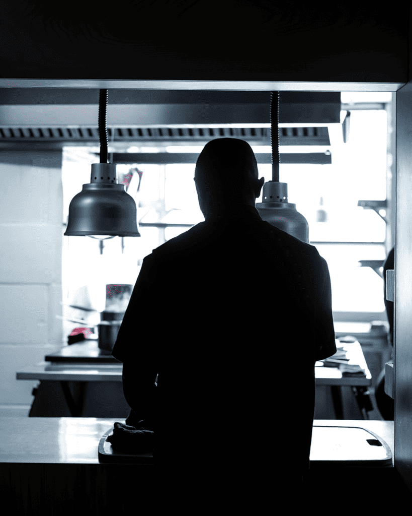 Silhouette of a chef in a gourmet restaurant kitchen.
