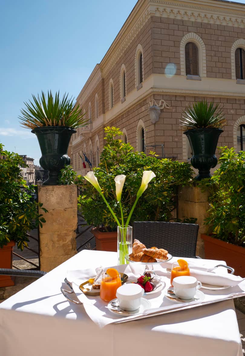 Outdoor breakfast in a gated garden at Risorgimento Resort in Lecce Italy.