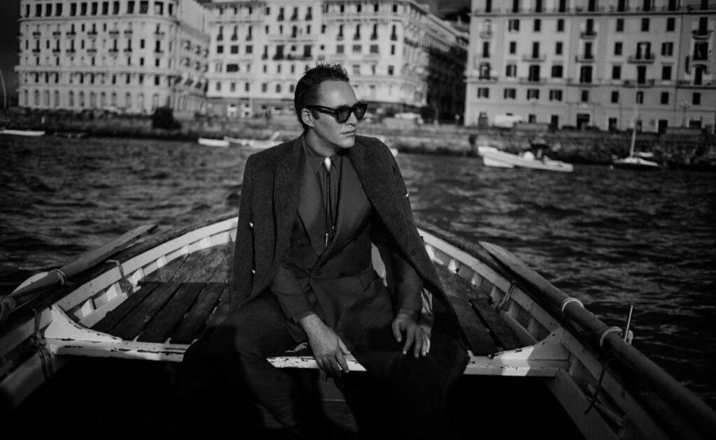 A stylish man in a gondola wearing Jaques Marie Mare men's sunglasses.